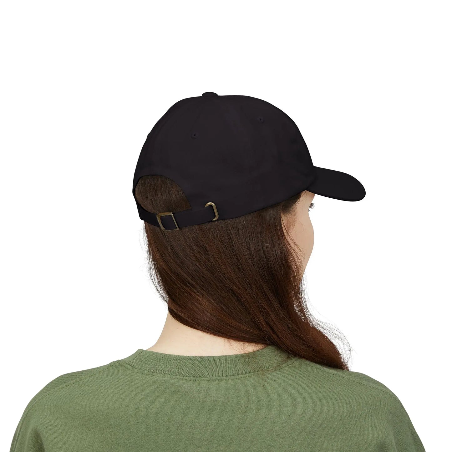 Back view of a person with long brown hair wearing a black cap from the Worldwide PRIDE store, featuring a rainbow design and the embroidered pronouns she/her, along with an olive green sweatshirt.