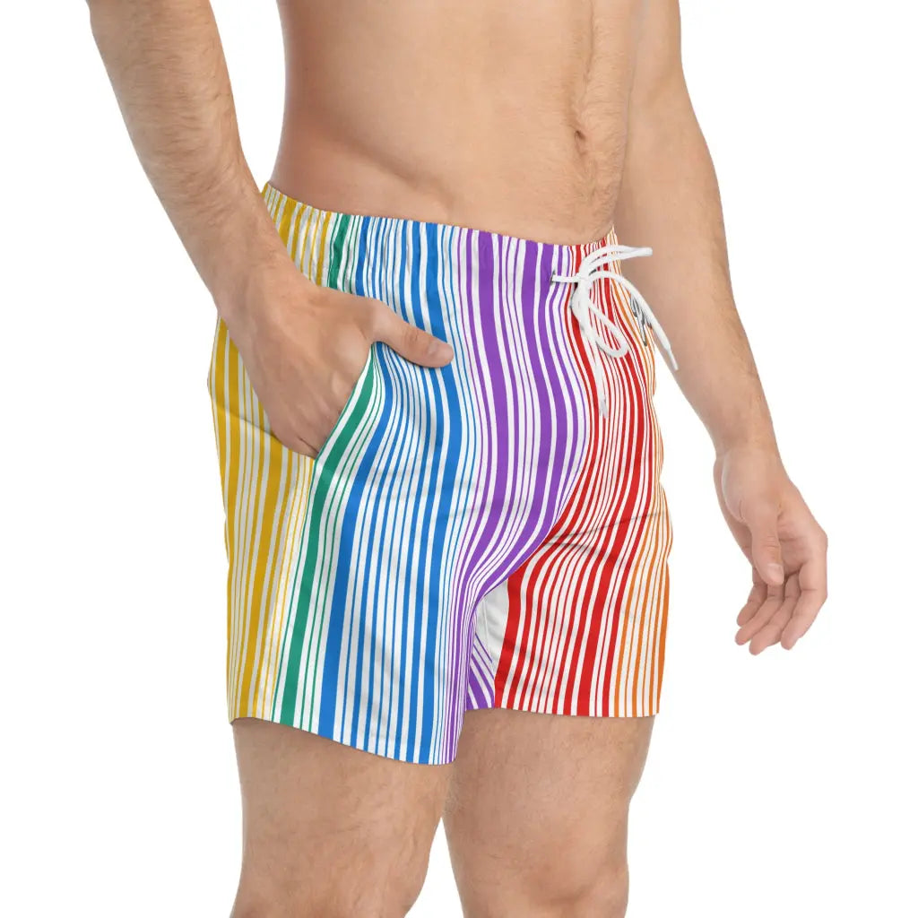 A person sports PRIDE Rainbow Swim Trunks, featuring a vibrant rainbow-striped design and quick-drying polyester. With one hand in the pocket and a white drawstring at the waist, they stand against a plain white backdrop.