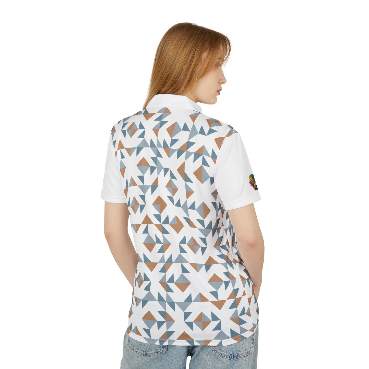 A person wears a white polo shirt featuring a geometric pattern with blue, brown, and white shapes. It features a collar, buttons, and a colorful lion on the left sleeve that embodies the spirit of Worldwide PRIDE. It is part of WWP's Subtlety collection.