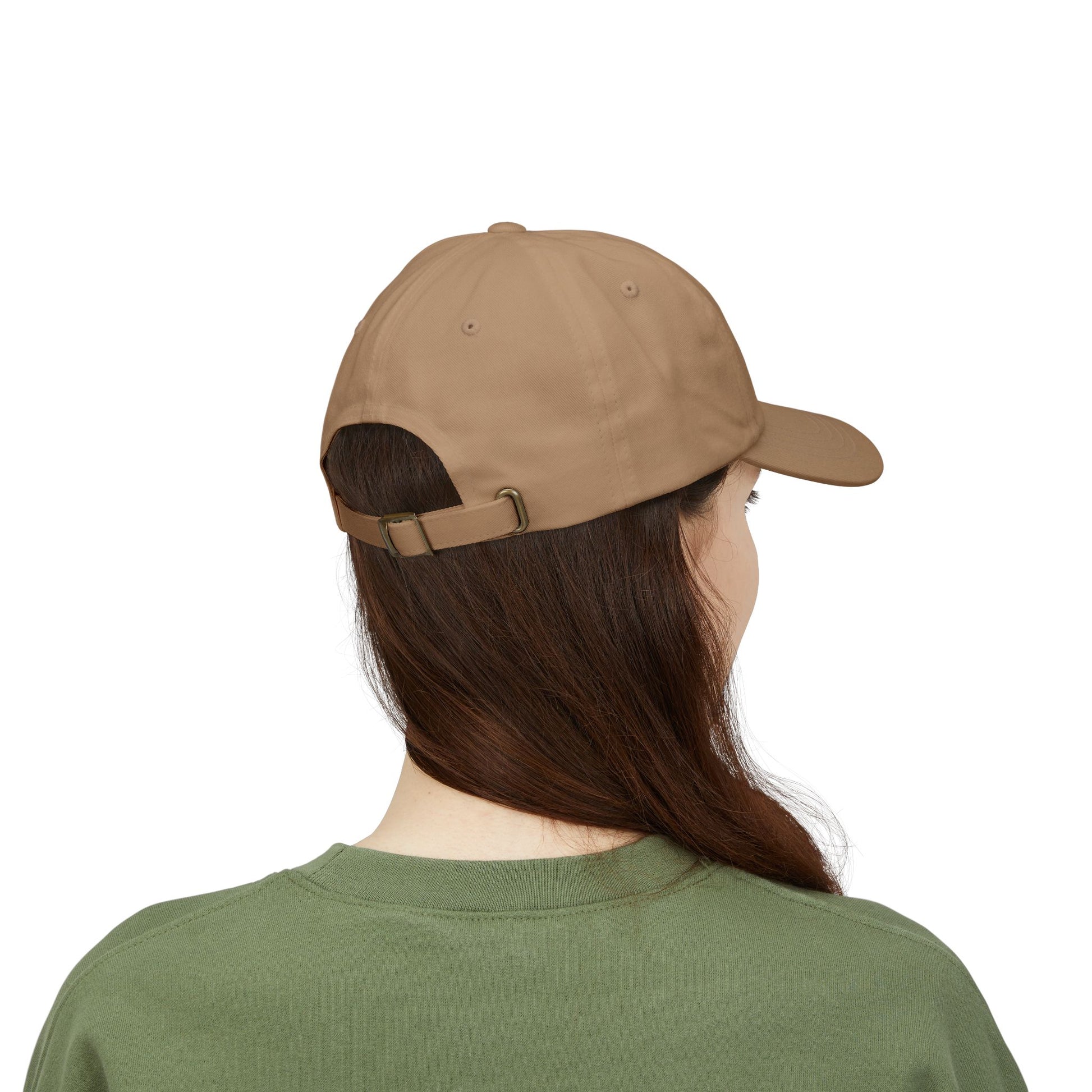 Back view of a person with long brown hair wearing a khaki cap from the Worldwide PRIDE store, featuring a rainbow design and the embroidered pronouns she/her, along with an olive green sweatshirt. 
