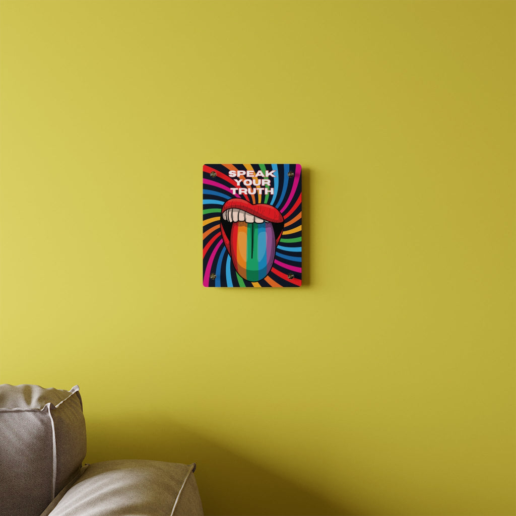Worldwide PRIDE presents a vibrant piece of wall art that depicts an open mouth with rainbow-colored lips and tongue against a swirling rainbow backdrop. The words Speak Your Truth celebrate the LGBTQ community. The 8"x10" art sits on a yellow wall above a sofa.