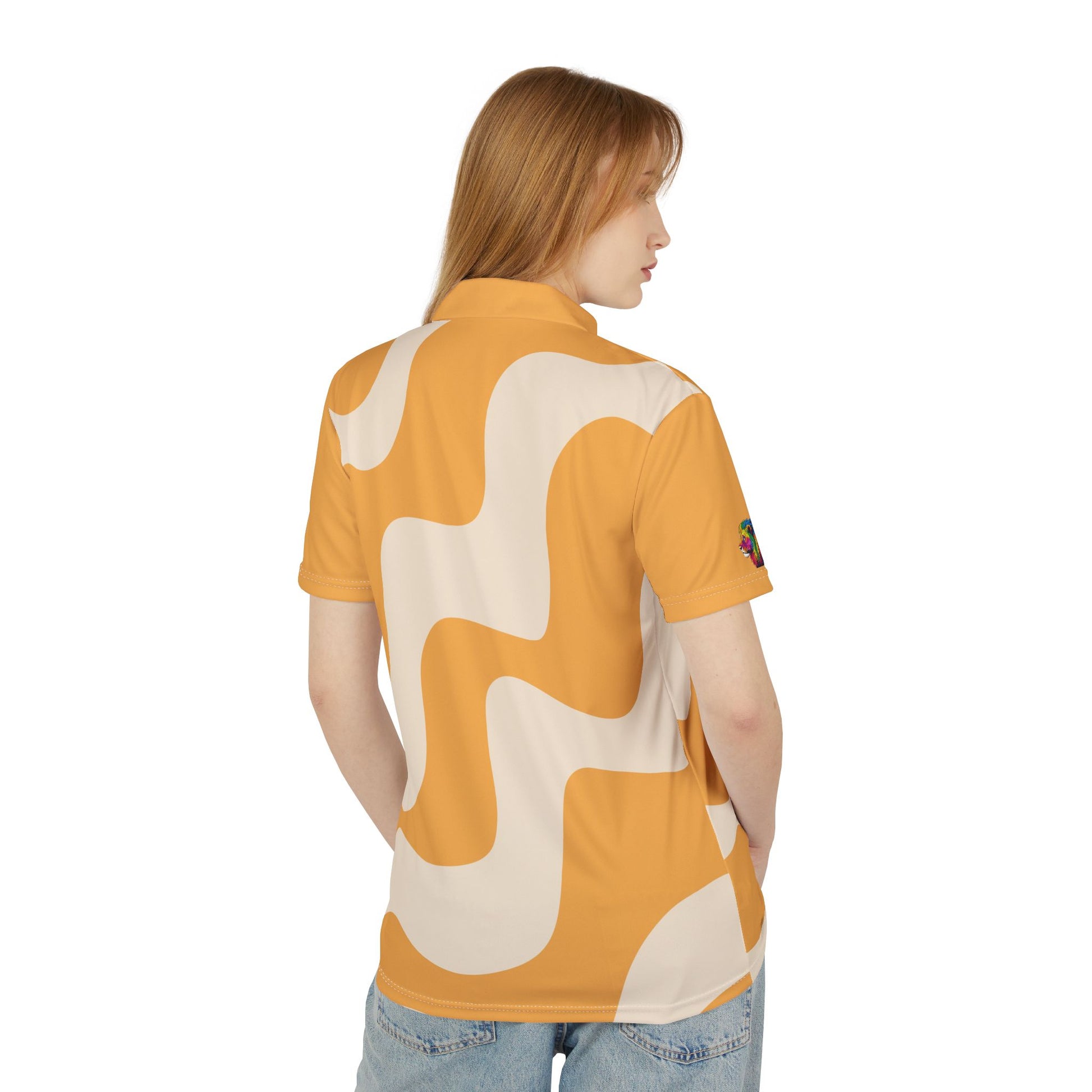 A person wears a polo shirt that features an abstract wavy pattern in mustard yellow and cream. With short sleeves and a vibrant lion on the right sleeve, it celebrates Worldwide PRIDE against a plain white backdrop.