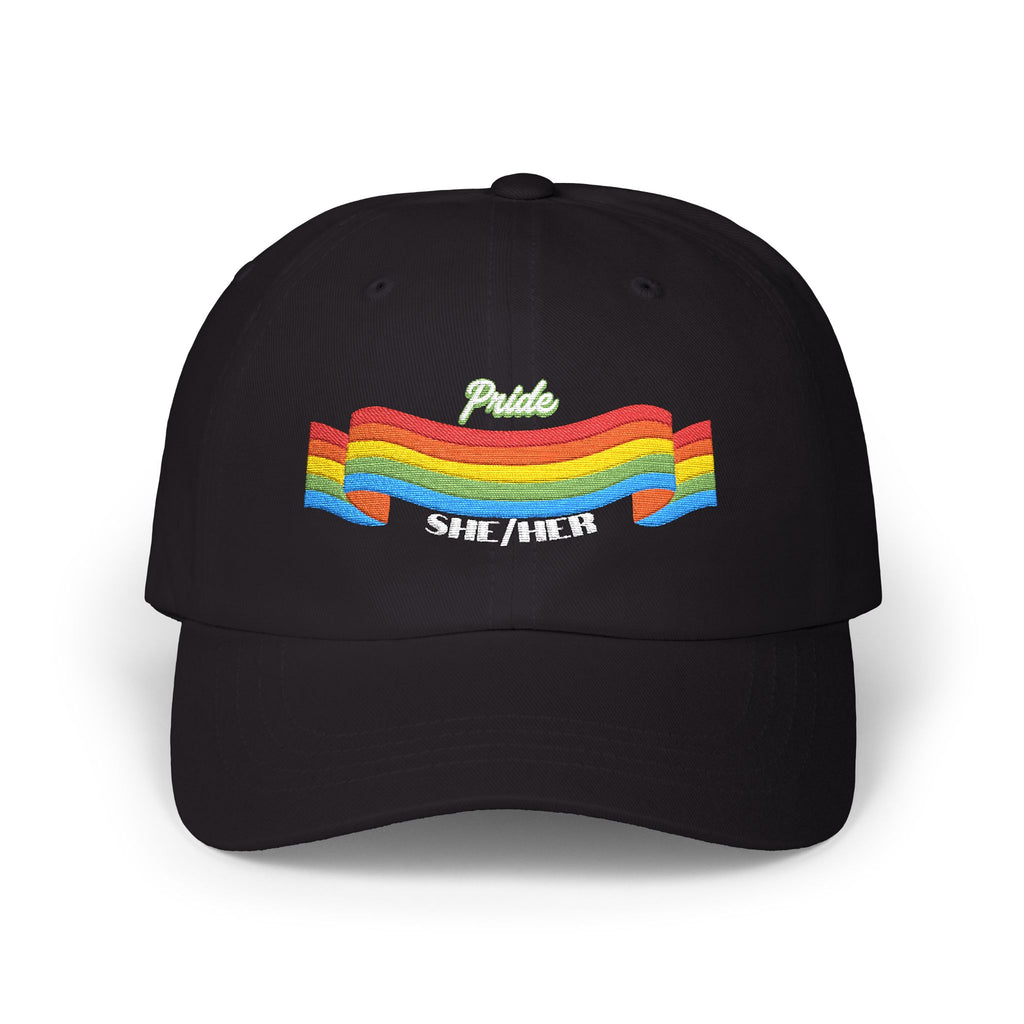 A black cap from the Worldwide PRIDE store, featuring a rainbow design and the embroidered pronouns she/her.