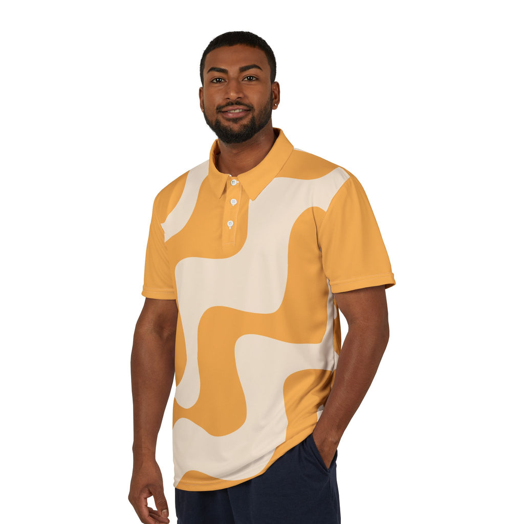 A person wears a polo shirt that features an abstract wavy pattern in mustard yellow and cream. With short sleeves and a vibrant lion on the right sleeve, it celebrates Worldwide PRIDE against a plain white backdrop.