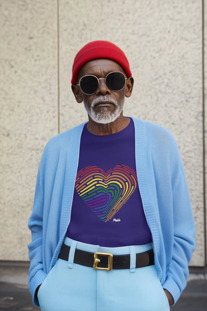 Man wearing a blue cardigan, purple shirt with rainbow fingerprint heart design, red beanie, and sunglasses against a textured wall.