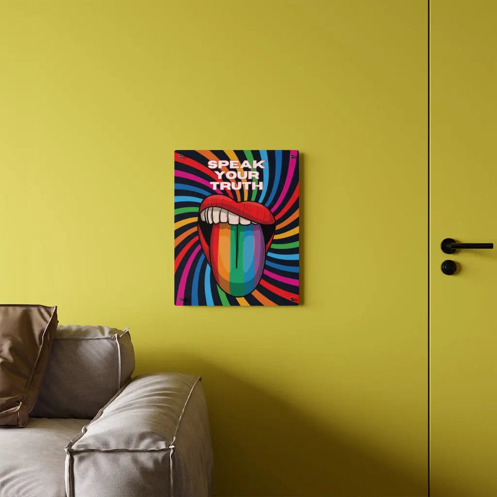 Worldwide PRIDE presents a vibrant piece of wall art that depicts an open mouth with rainbow-colored lips and tongue against a swirling rainbow backdrop. The words Speak Your Truth celebrate the LGBTQ community. The 16"x20" art sits on a yellow wall above a sofa.