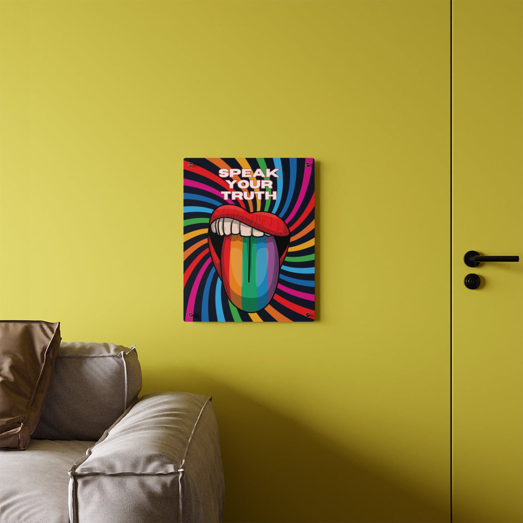 Worldwide PRIDE presents a vibrant piece of wall art that depicts an open mouth with rainbow-colored lips and tongue against a swirling rainbow backdrop. The words Speak Your Truth celebrate the LGBTQ community. The 16"x20" art sits on a yellow wall above a sofa.