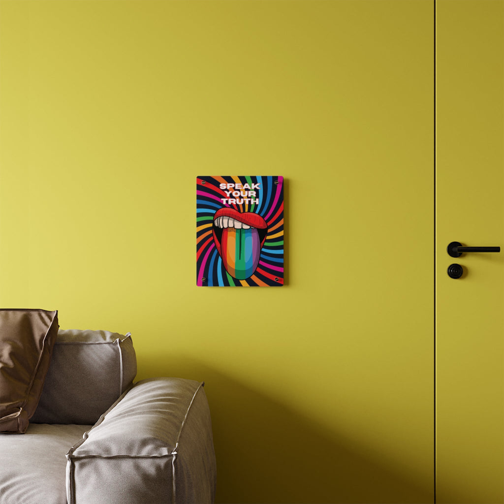 Worldwide PRIDE presents a vibrant piece of wall art that depicts an open mouth with rainbow-colored lips and tongue against a swirling rainbow backdrop. The words Speak Your Truth celebrate the LGBTQ community. The 11"x14" art sits on a yellow wall above a sofa.