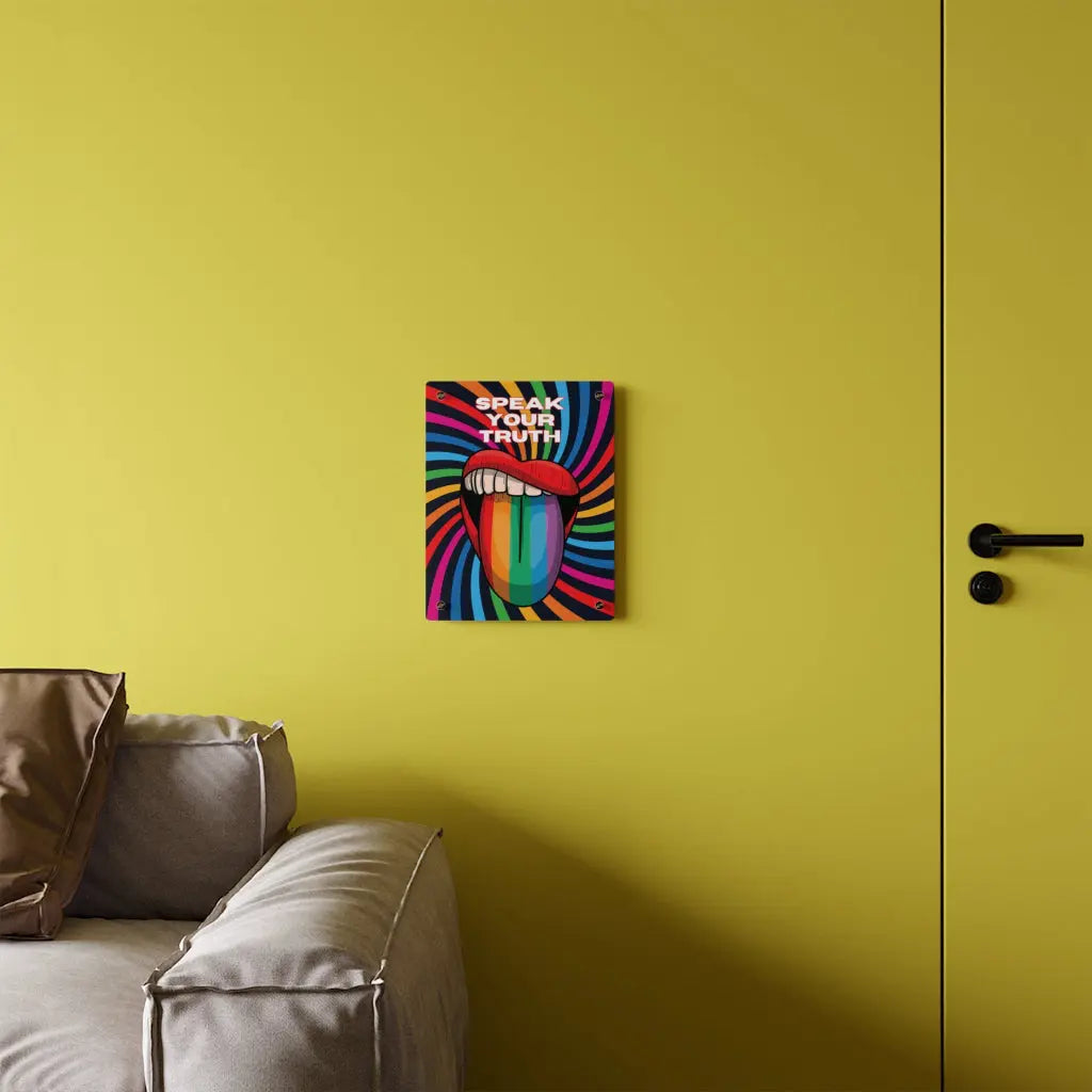 Worldwide PRIDE presents a vibrant piece of wall art that depicts an open mouth with rainbow-colored lips and tongue against a swirling rainbow backdrop. The words Speak Your Truth celebrate the LGBTQ community. The 11"x14" art sits on a yellow wall above a sofa.