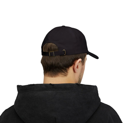 Back view of a person with short brown hair wearing a black cap from the Worldwide PRIDE store, featuring a rainbow design and the embroidered pronouns he/him. The person is also wearing a black hooded sweatshirt and looking down.