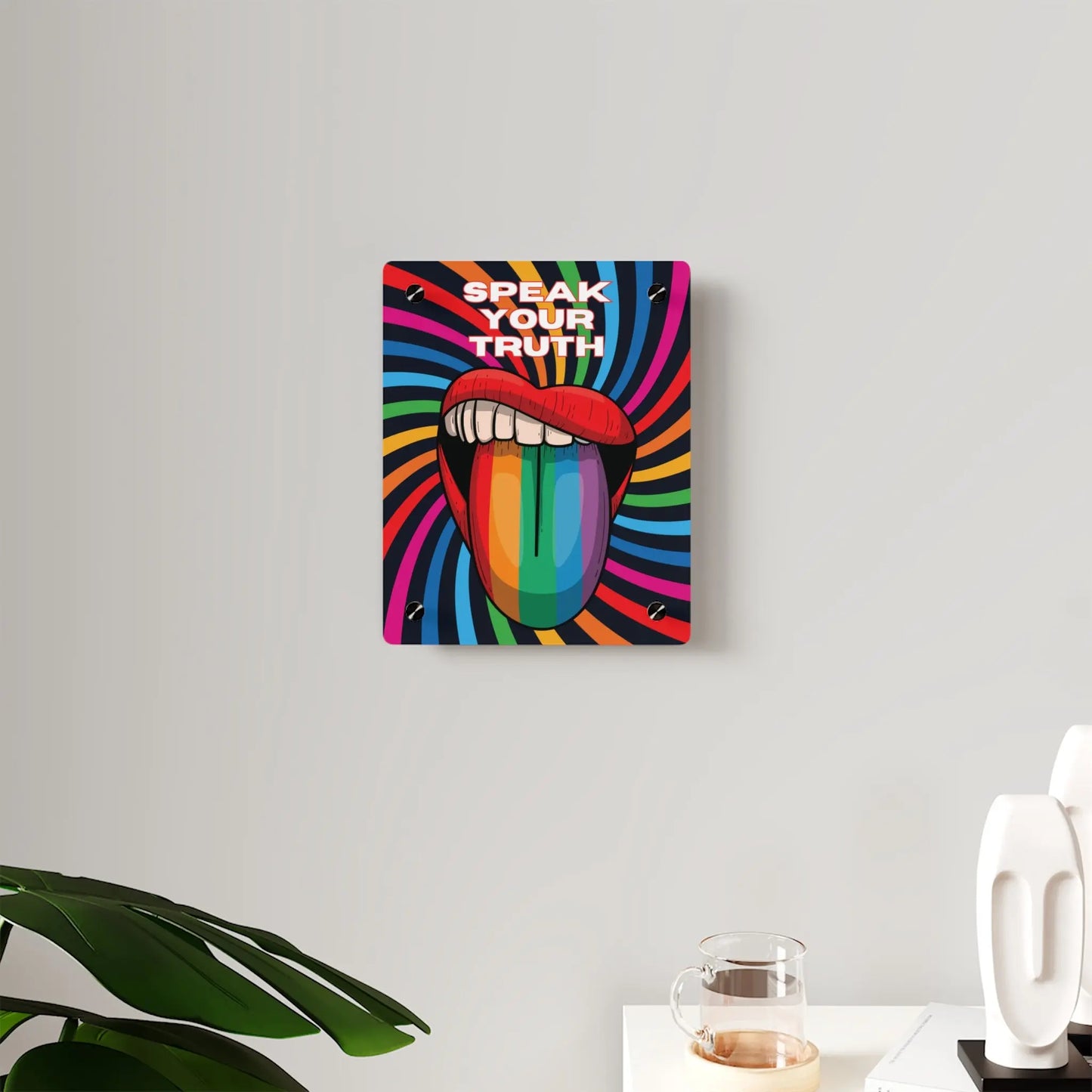 Worldwide PRIDE presents a vibrant piece of wall art that depicts an open mouth with rainbow-colored lips and tongue against a swirling rainbow backdrop. The words Speak Your Truth celebrate the LGBTQ community. Nearby, a plant and decorative items add charm to the scene.