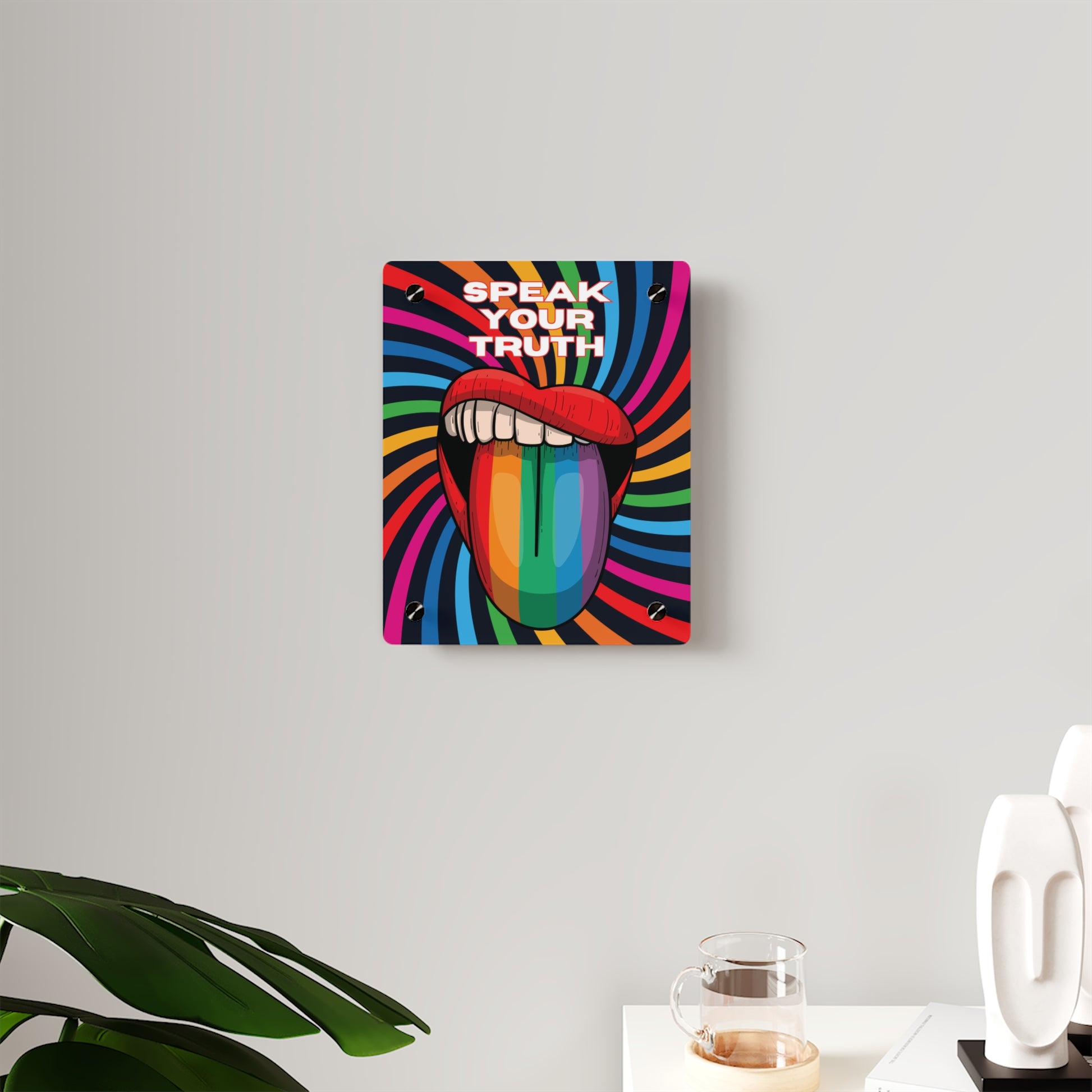 Worldwide PRIDE presents a vibrant piece of wall art that depicts an open mouth with rainbow-colored lips and tongue against a swirling rainbow backdrop. The words Speak Your Truth celebrate the LGBTQ community. Nearby, a plant and decorative items add charm to the scene.