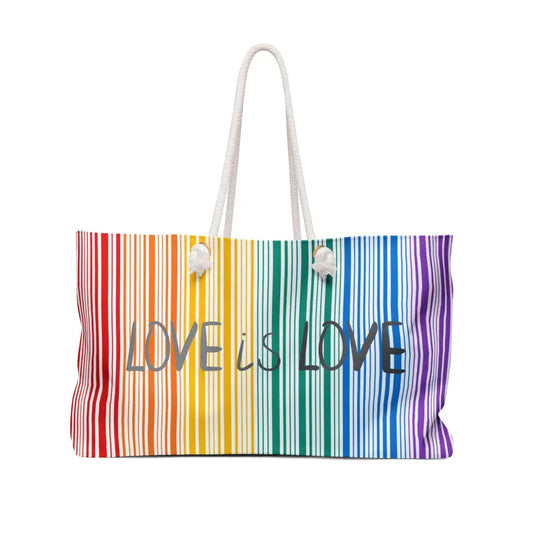 A weekender bag with rainbow stripes and the text Love is Love prominently in the center celebrates PRIDE. The bag, a tribute to the LGBTQ community, features white rope handles that stand out against a pristine white background.