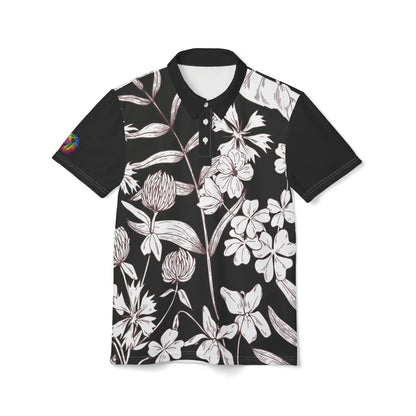 A black and white leaf and flower polo shirt from the Worldwide PRIDE Subtlety collection. On the right sleeve is a small colorful lion, an homage to the LBGTQ community. The person is placed against a plain white backdrop.
