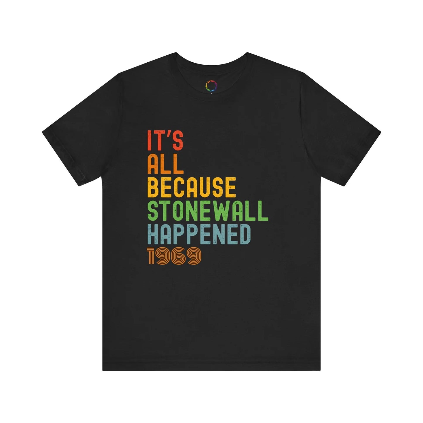 A black unisex short-sleeve t-shirt with the text 'IT'S ALL BECAUSE STONEWALL HAPPENED' printed in bold, multicolored letters.