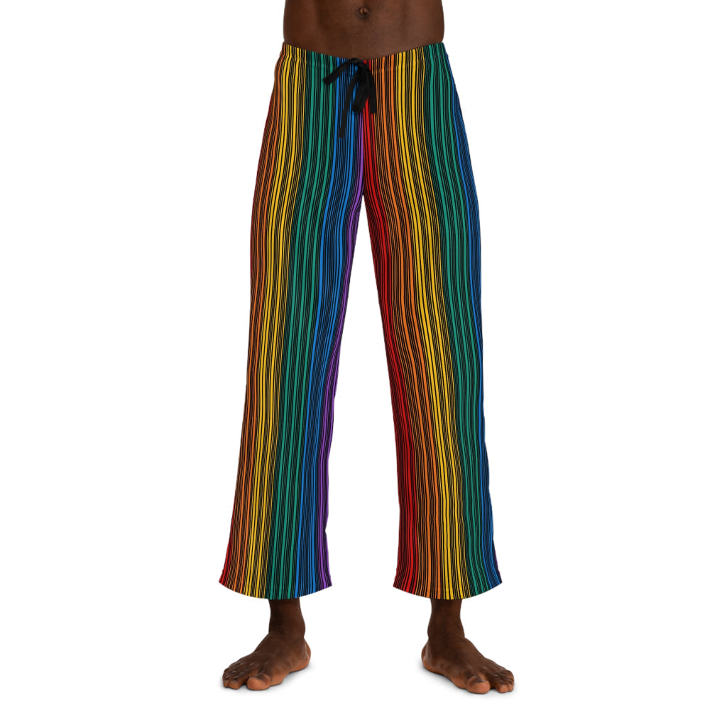 A person wearing colorful striped pants featuring vertical rainbow lines stands barefoot against a plain white background. Embracing the spirit of Worldwide PRIDE, these pants, with their drawstring waist, reflect the vibrant energy of the LGBTQ community. The persons upper body is not visible.