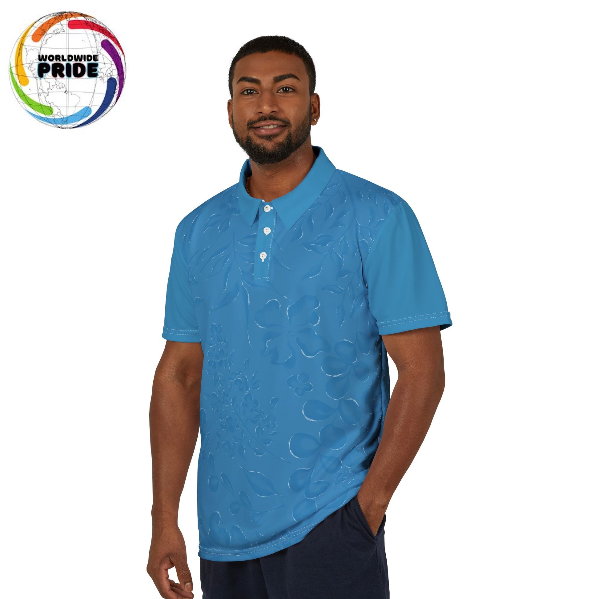 A person wears a blue polo shirt that features a flowery pattern with short sleeves and a vibrant lion on the right sleeve. It celebrates Worldwide PRIDE against a plain white backdrop.