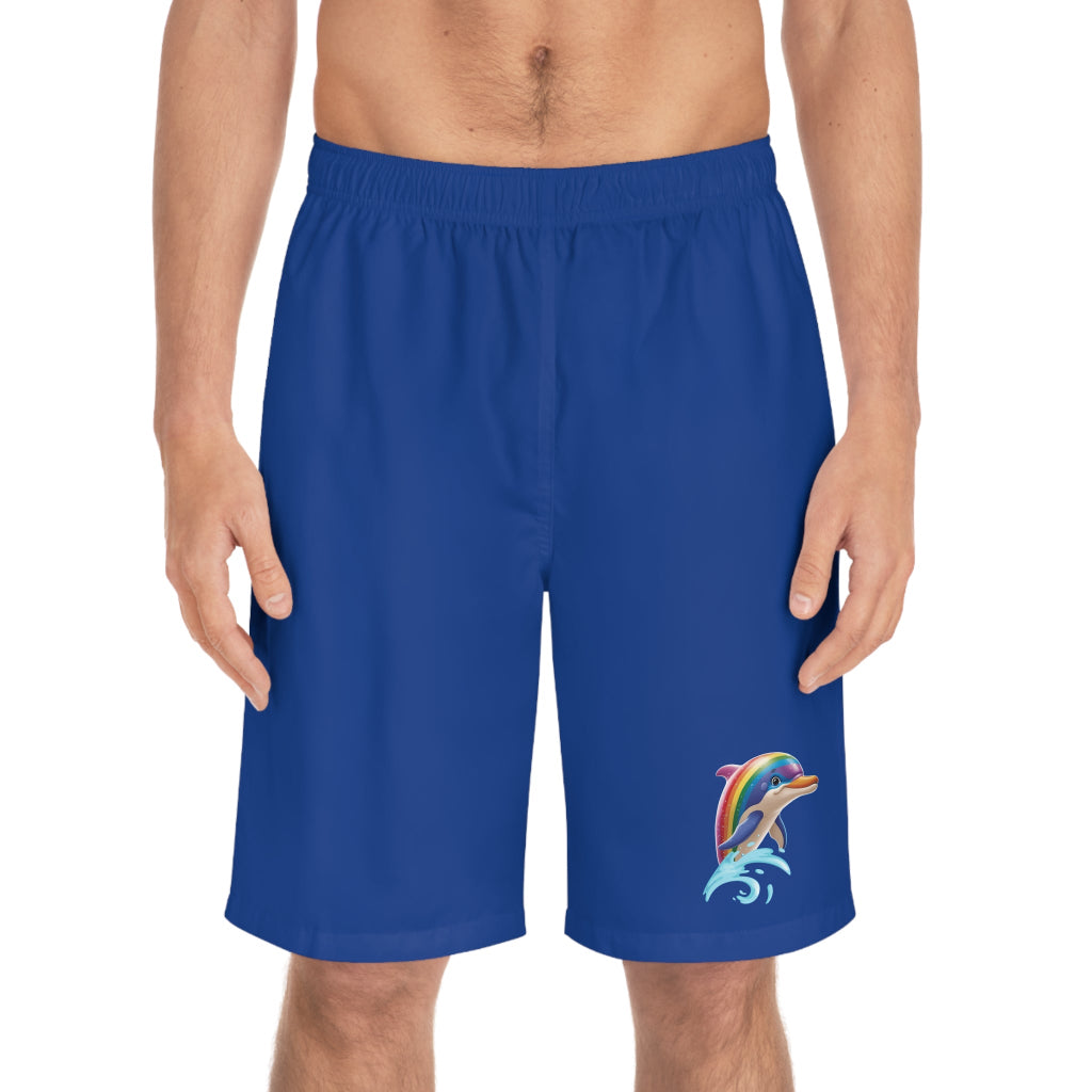 A person is wearing blue board shorts with a vibrant dolphin design near the hem, celebrating PRIDE. The shorts feature an elastic waistband, the rainbow-colored dolphin is leaping from the water reflecting a bold spirit embraced by the LGBTQ community.