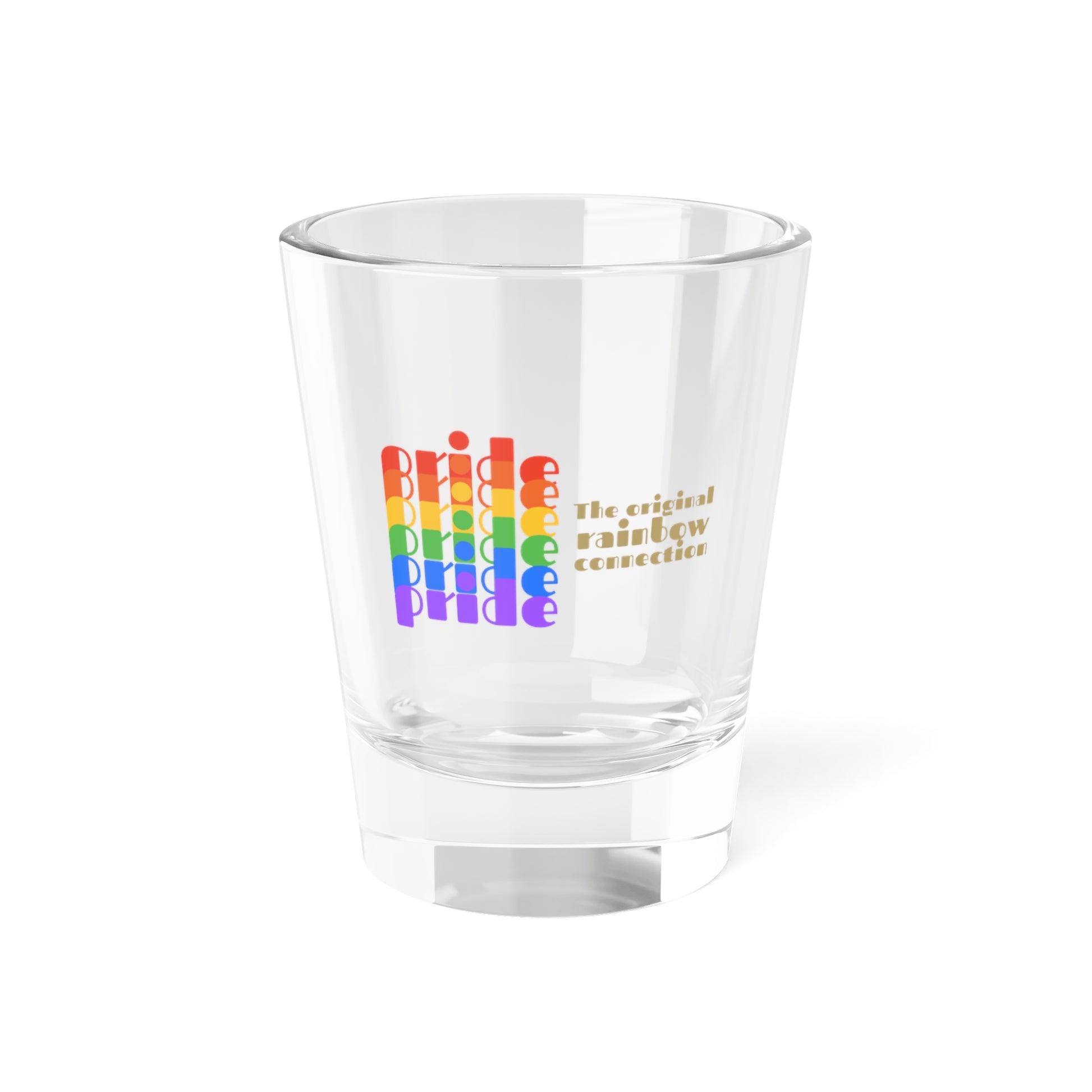 A clear shot glass features pride in a rainbow gradient on the left, celebrating the LGBTQ community. On the right, it reads The original rainbow connection in gold text. The glass, symbolizing worldwide PRIDE, sits empty against a white background.