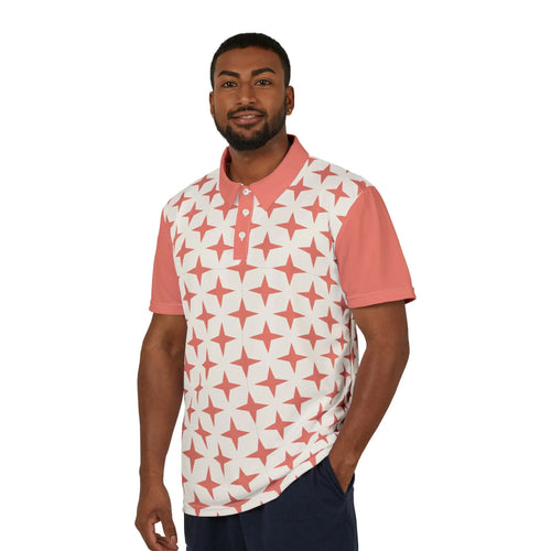 A man wears an eye-catching polo shirt featuring a coral collar and sleeves, with a white front and back adorned in coral stars. The shirt also features a small rainbow colored lion on the right sleeve. It's a subtle homage to the LGBTQ community.