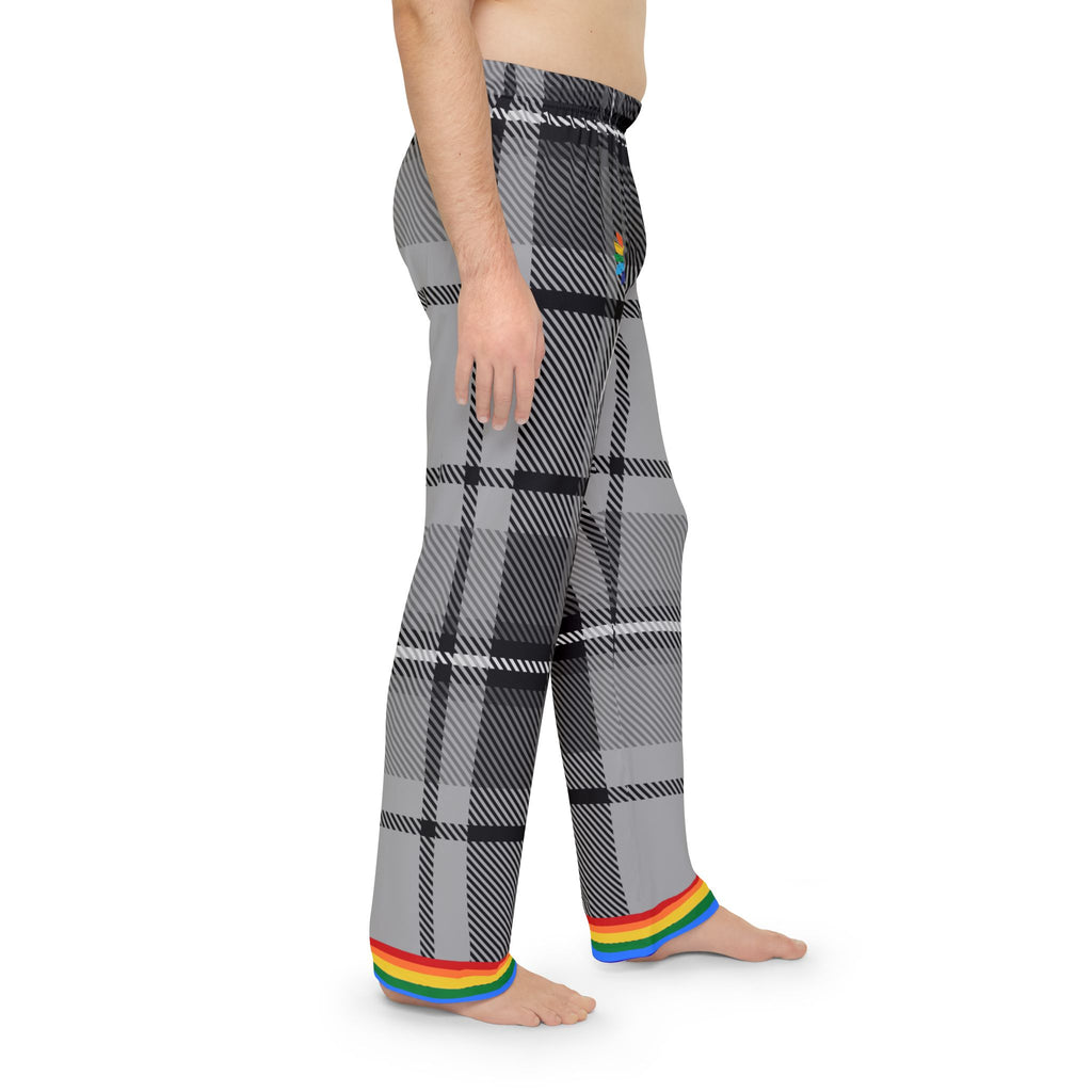 A person is standing barefoot, wearing gray and black plaid pants with a rainbow trim at the cuffs. The persons torso is not covered by any clothing. The pants feature a subtle rainbow detail near the waistband. The background is plain white.