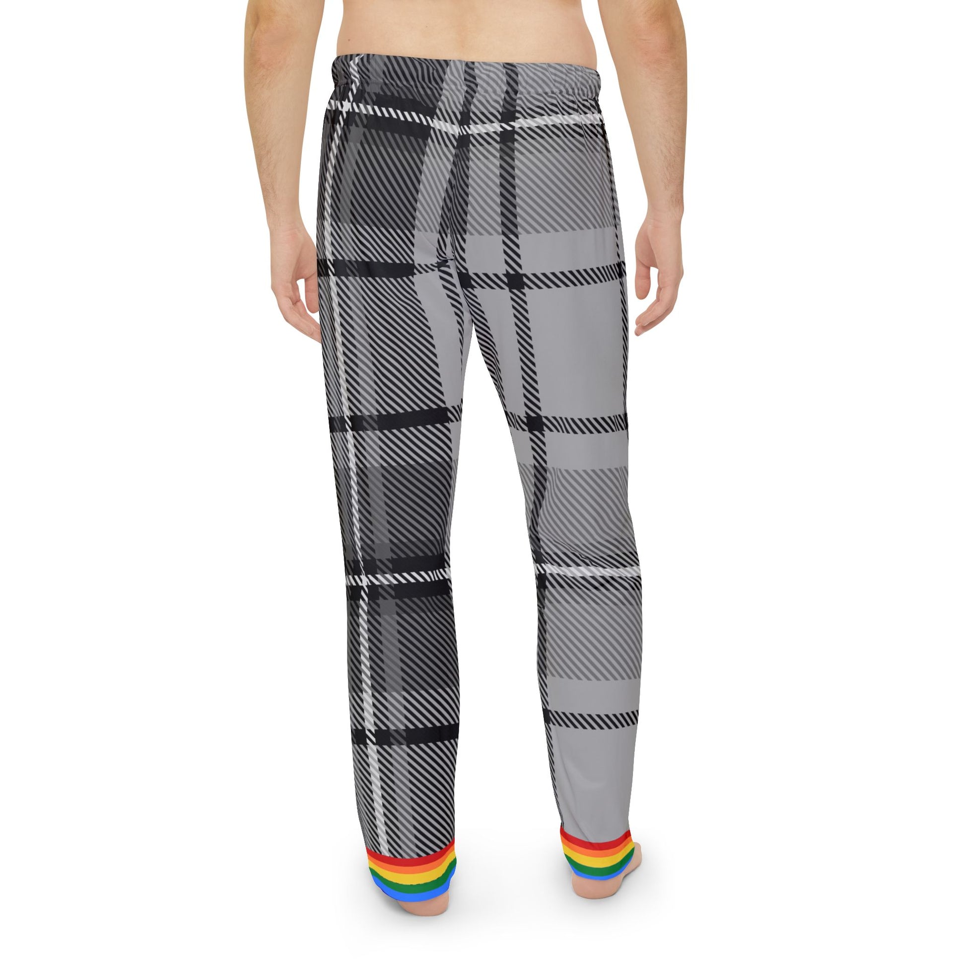 A person is standing barefoot facing away from the camera. They are wearing gray and black plaid pants with a rainbow trim at the cuffs. The persons torso is not covered by any clothing. The background is plain white.