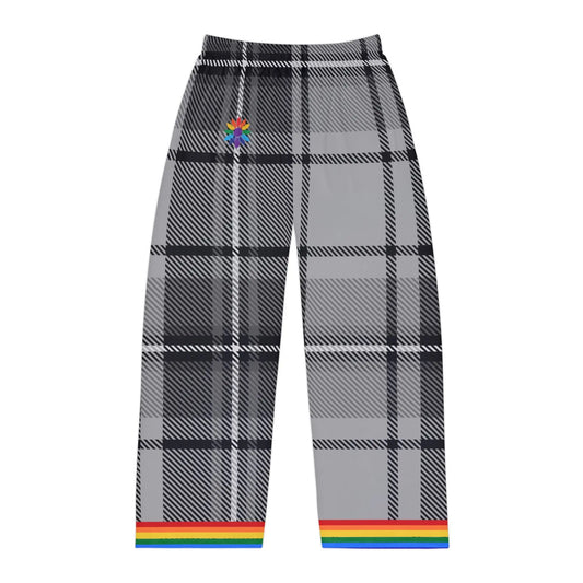 A photo of gray and black plaid pants with a rainbow trim at the cuffs. The pants feature a subtle rainbow-pedaled flower detail near the waistband. The background is plain white.