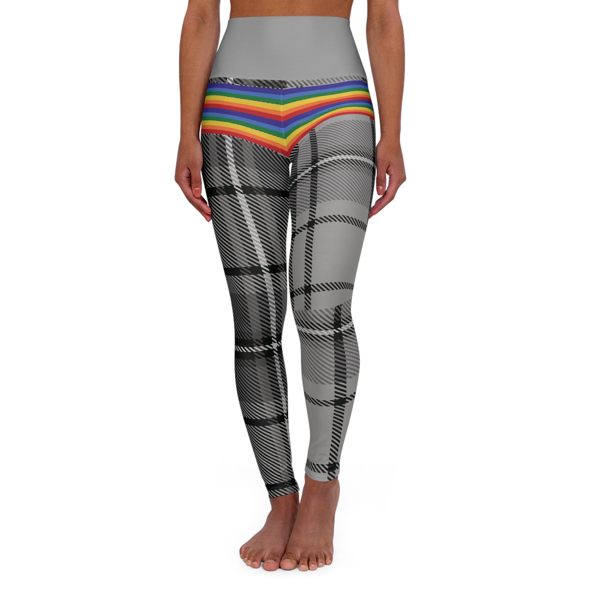 Person wearing leggings with a grey waistband, rainbow-striped midsection, and black-and-white plaid pattern on the legs. The person is barefoot and standing against a white background.
