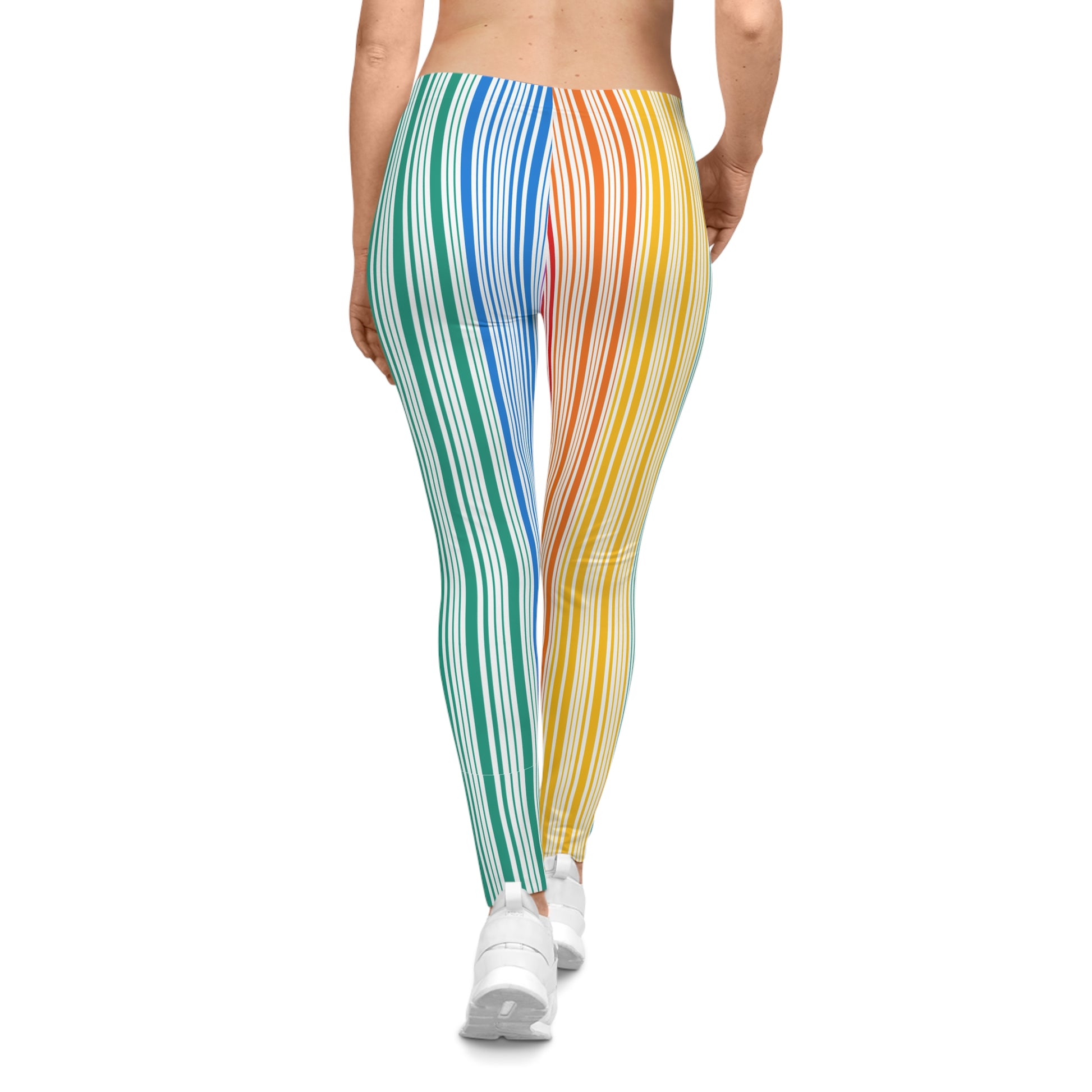 A person wearing colorful leggings with vertical stripes in a gradient from blue to red embodies the spirit of PRIDE. They are also wearing white sneakers and standing against a plain white background, celebrating vibrancy and diversity.