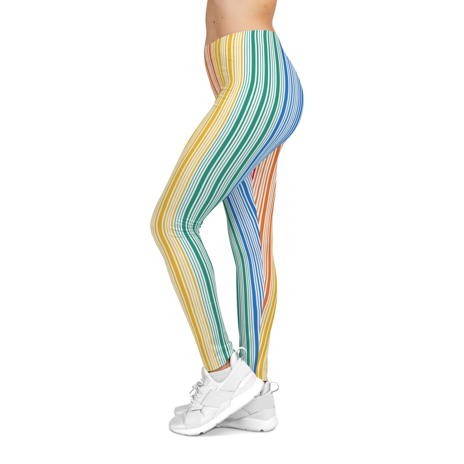 A person wearing colorful leggings with vertical stripes in a gradient from blue to red embodies the spirit of PRIDE. They are also wearing white sneakers and standing against a plain white background, celebrating vibrancy and diversity.