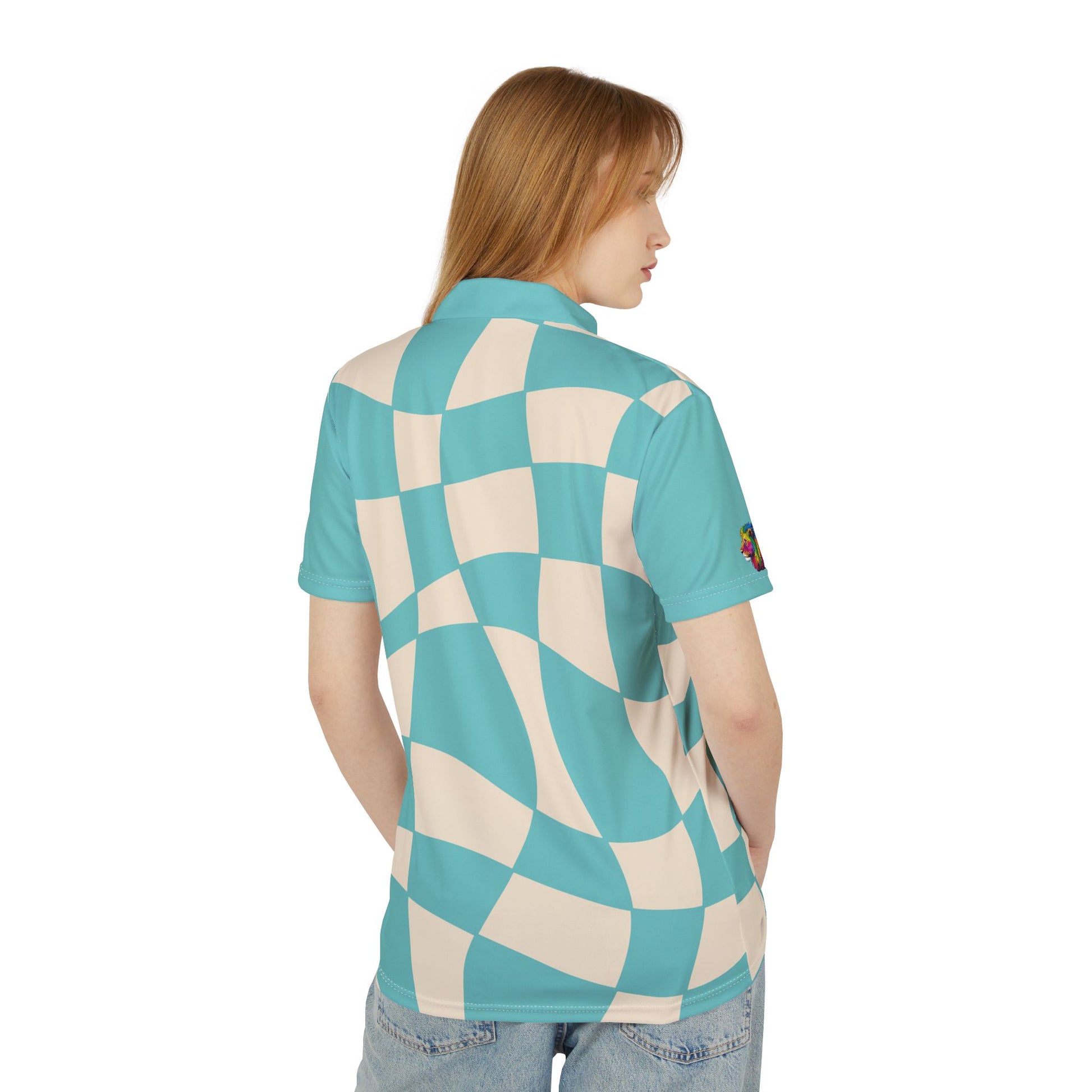 A person wears a polo shirt, part of the Subtlety collection, showcases a teal and cream checkered pattern. It features a colorful lion on the right sleeve and a button-up collar, embodying Worldwide PRIDE with its vibrant design.