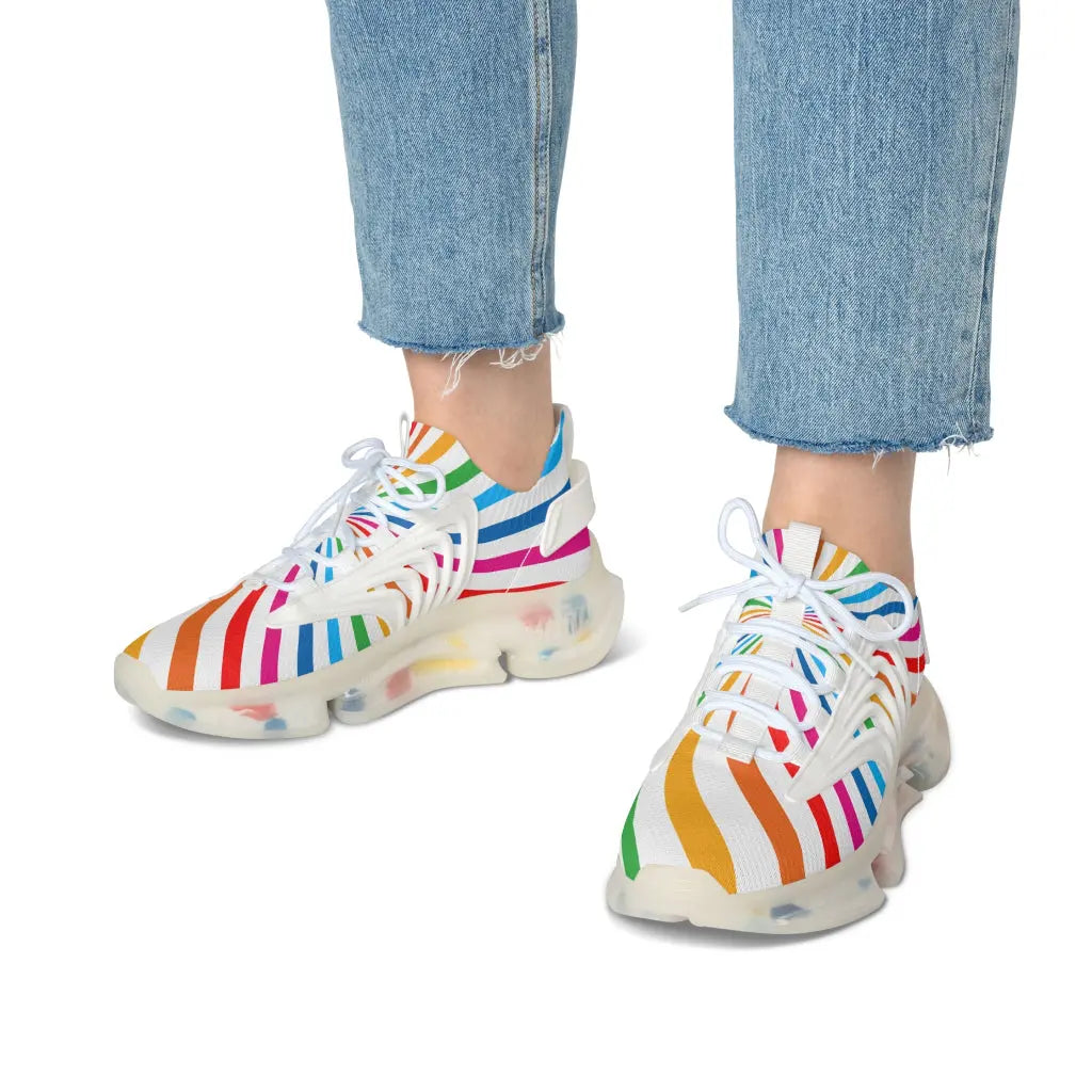 A person wearing colorful striped sneakers paired with light blue, frayed hem jeans celebrates Worldwide PRIDE. The vibrant sneakers with translucent soles echo the spirit of the LGBTQ community against a plain white background.