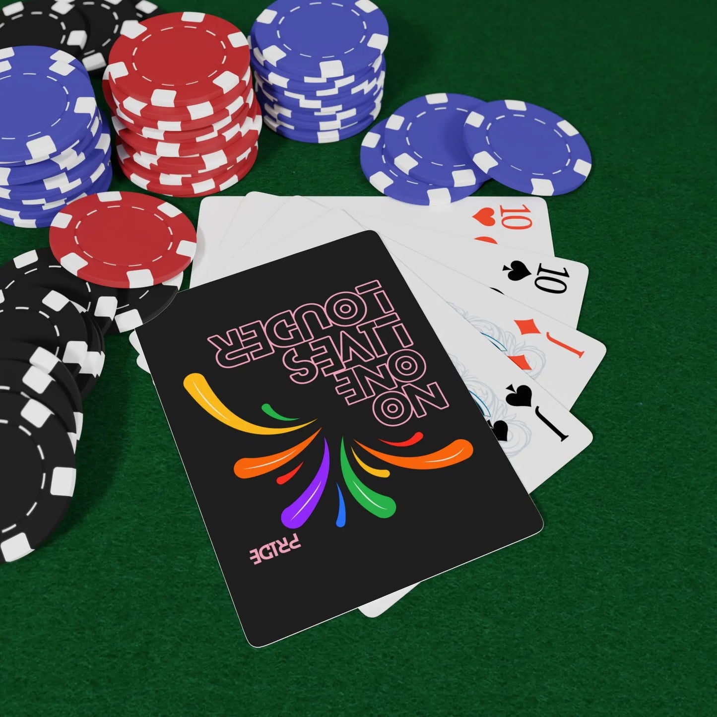 Poker chips, playing cards, and a deck of cards with colorful design on a green felt surface.