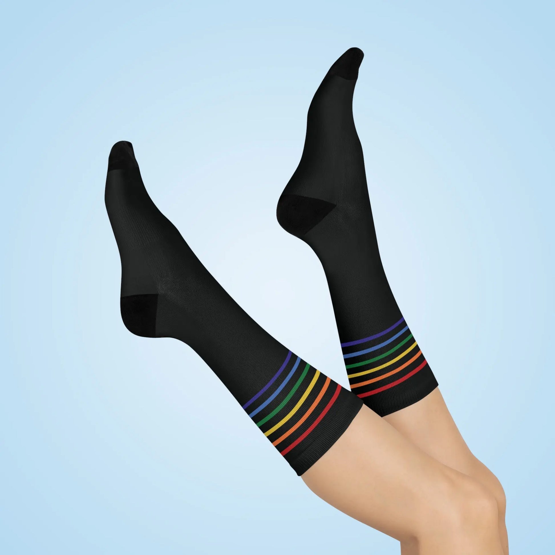 A pair of black crew socks with a colorful striped pattern representing the LGBTQ community.