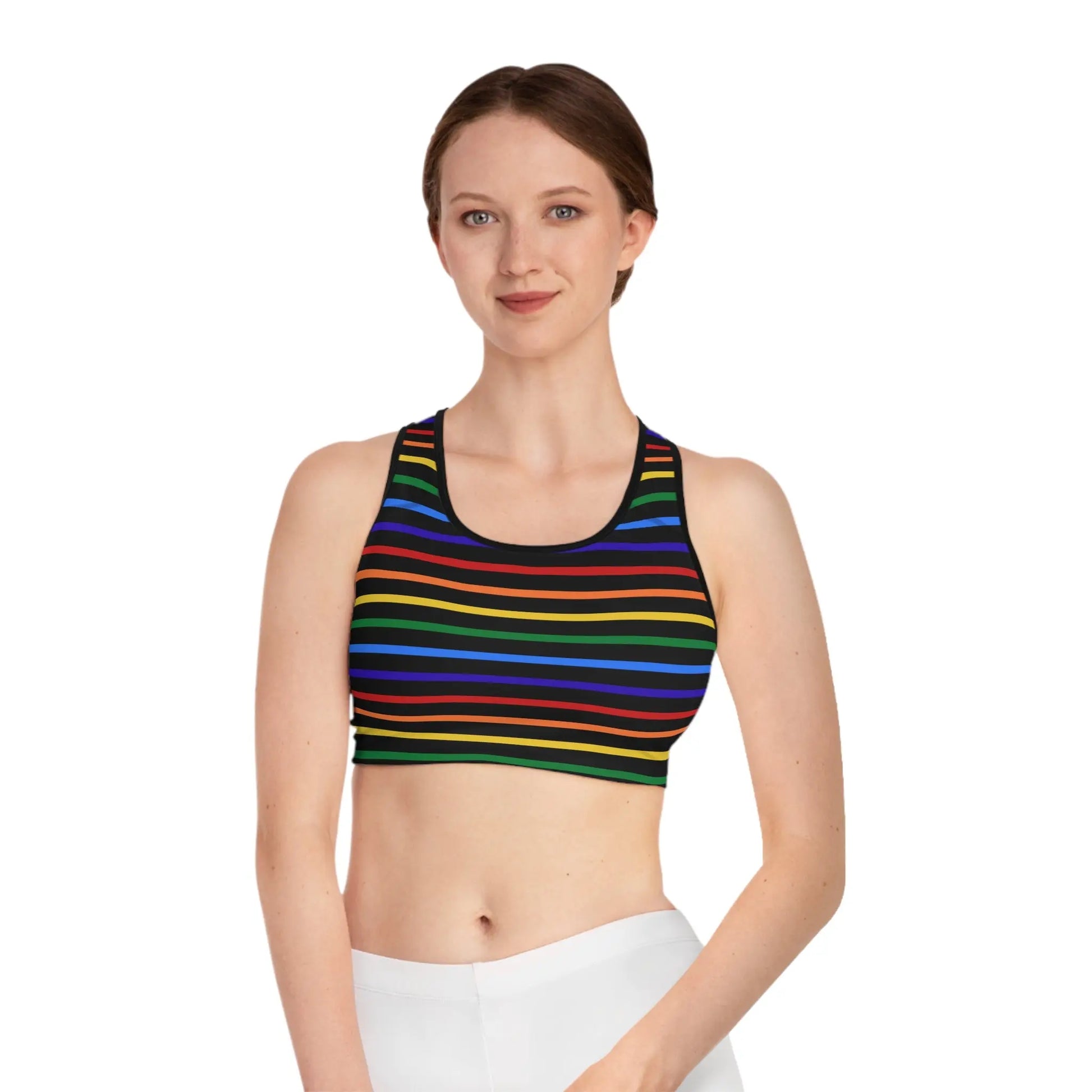 Person wearing a rainbow striped sports bra on a white background