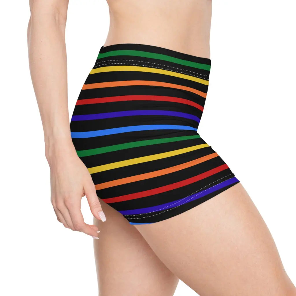 A pair of women's shorts featuring a striped pattern a glittery heart, and vibrant rainbow colors on a black background.