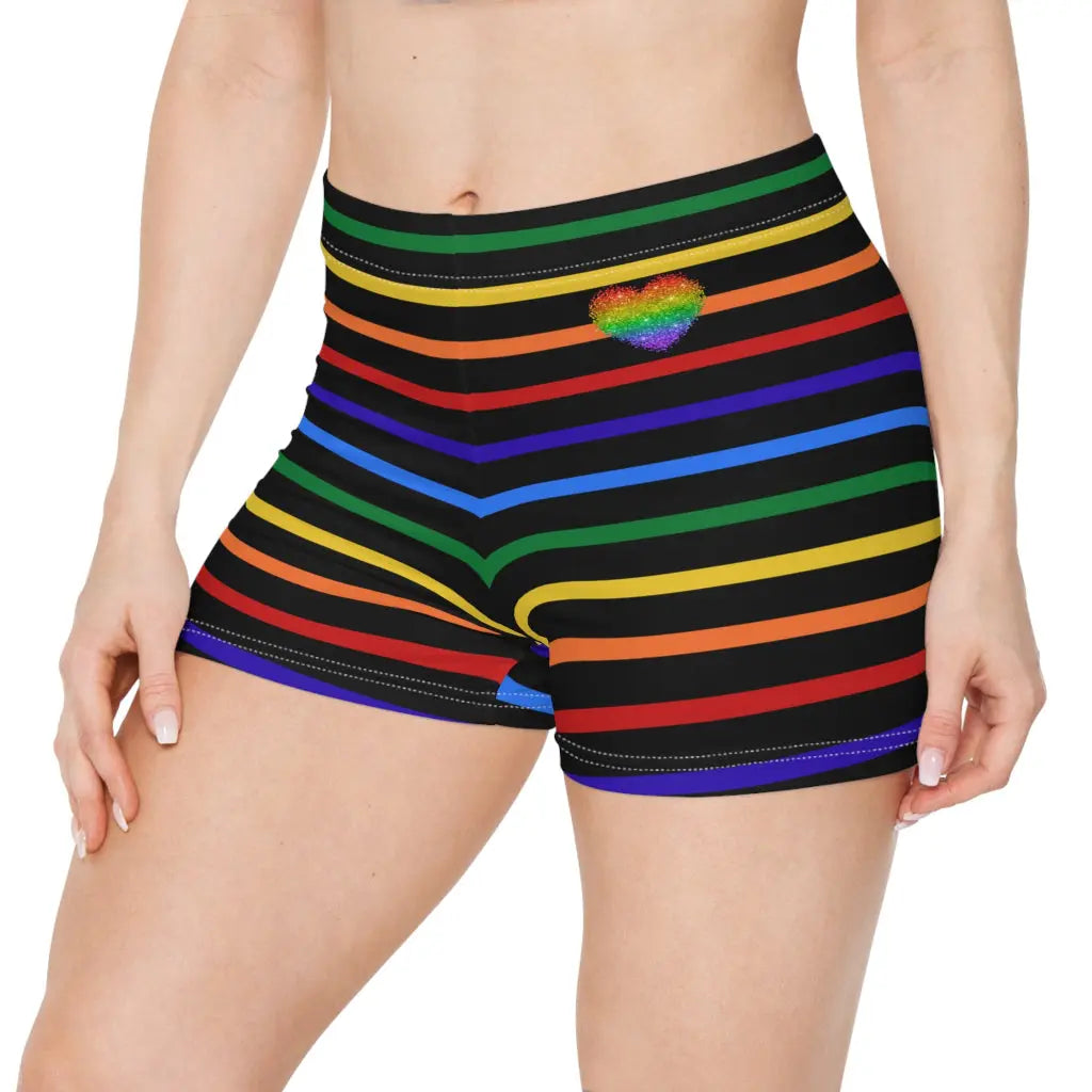 A pair of women's shorts featuring a striped pattern a glittery heart, and vibrant rainbow colors on a black background.