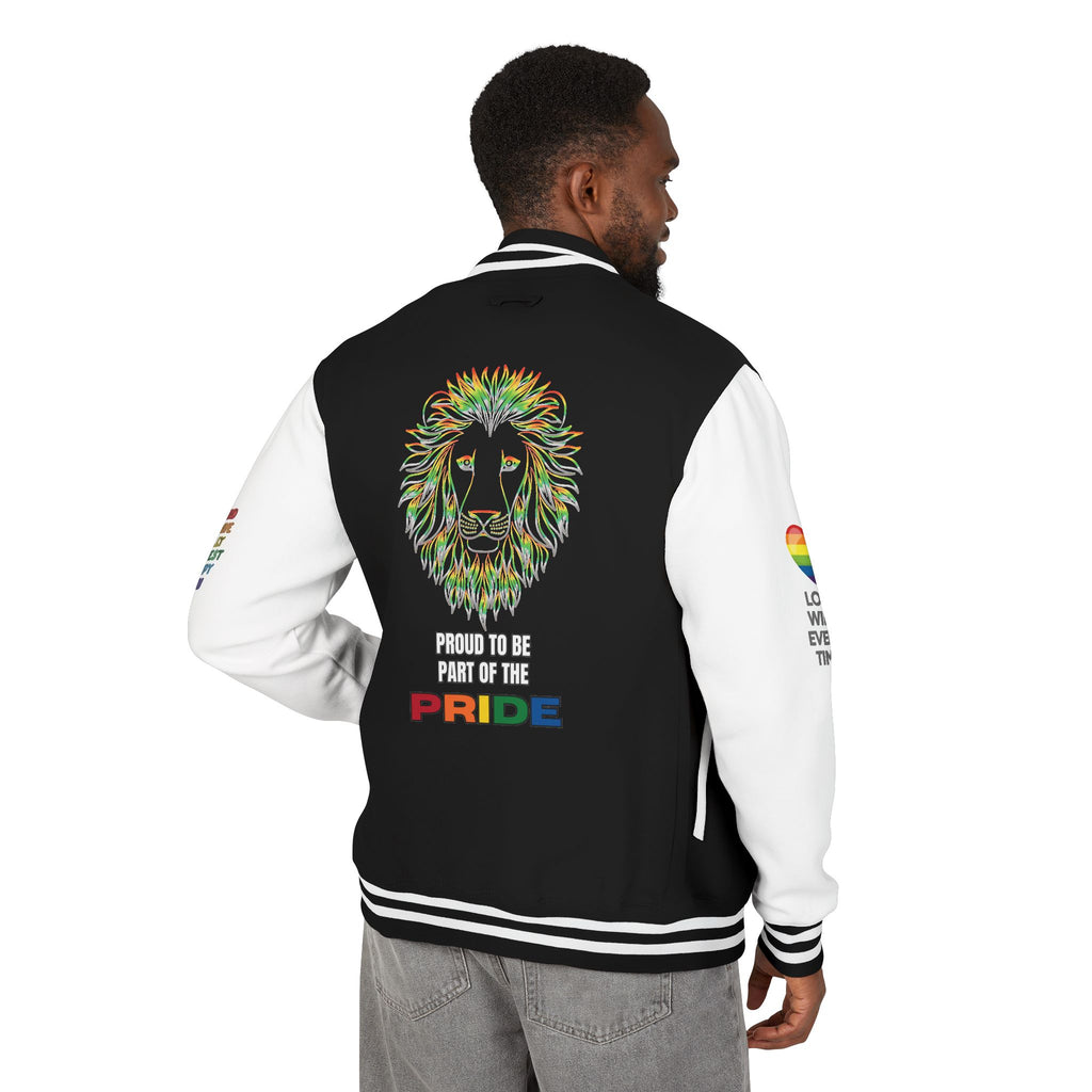 A person stands smiling showing the back of a black and white letterman jacket featuring a rainbow-colored lion face, the text PROUD TO BE PART OF THE PRIDE, and rainbow heart designs with positive messages on both sleeves.