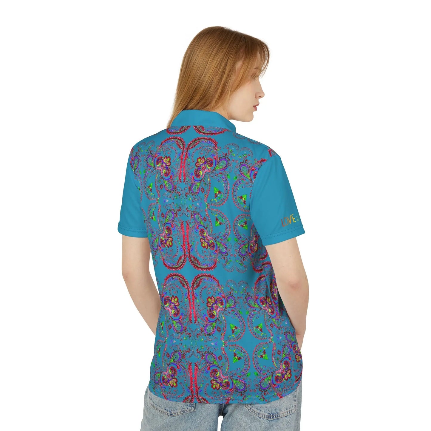 A person wearing a polo shirt with a blue background featuring a red paisley pattern.