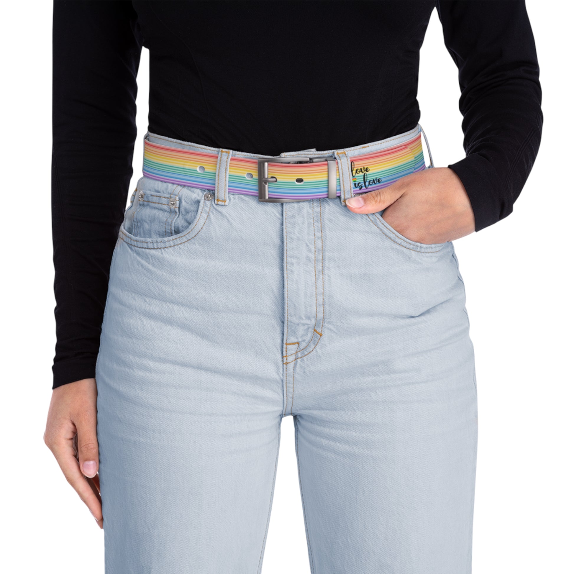 A person wearing a black long-sleeve shirt and light blue jeans with the Worldwide PRIDE rainbow-striped Love is Love belt with gun metal buckle, showing support for the LGBTQ+ community, with one hand in their pocket.
