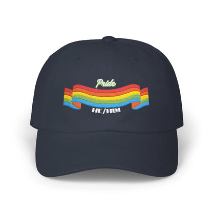 A navy blue cap from the Worldwide PRIDE store, featuring a rainbow design and the embroidered pronouns he/him.