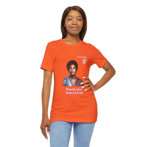 Person wearing an orange t-shirt with a graphic of Audre Lorde and text on a white background