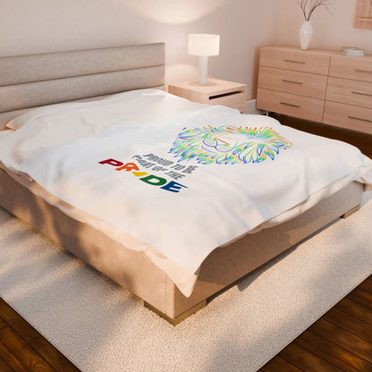 White throw blanket with rainbow lion design and 'Proud to be part of the Pride' text on a bed.