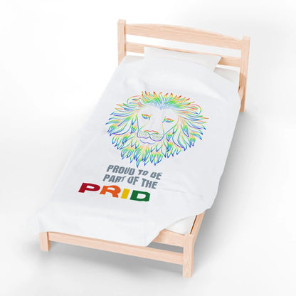 White blanket with rainbow lion design and 'Proud to be part of the Pride' text on a bed.