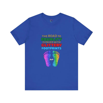 A royal blue unisex short-sleeve t-shirt with a graphic of multicolored glitter footprints and the text 'THE ROAD TO EQUALITY IS LITTERED WITH GLITTERY FOOTPRINTS'.