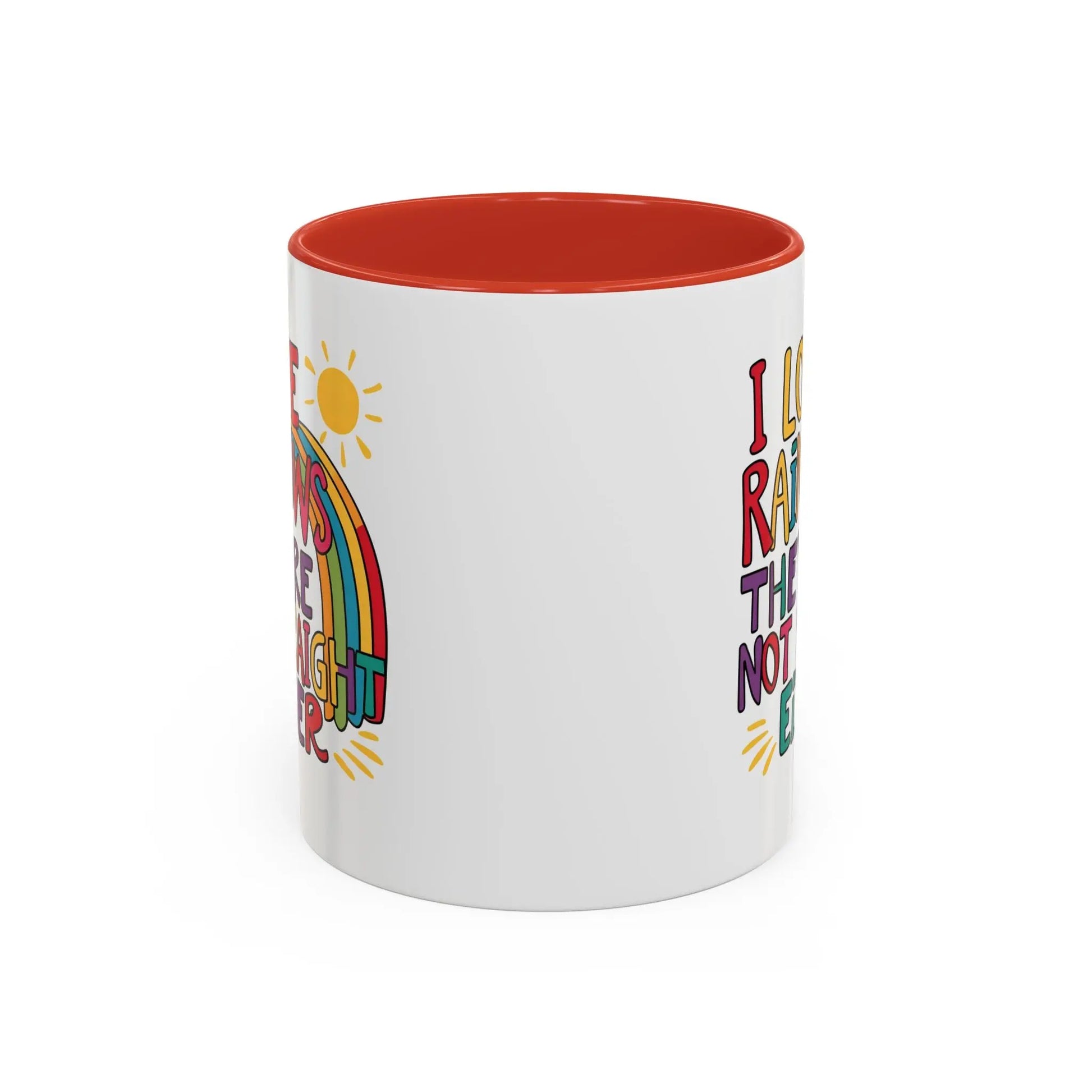 A white ceramic coffee mug with a red handle and interior, featuring the colorful text 'I LOVE RAINBOWS THEY'RE NOT STRAIGHT EITHER' along with a graphic of a rainbow and a sun.