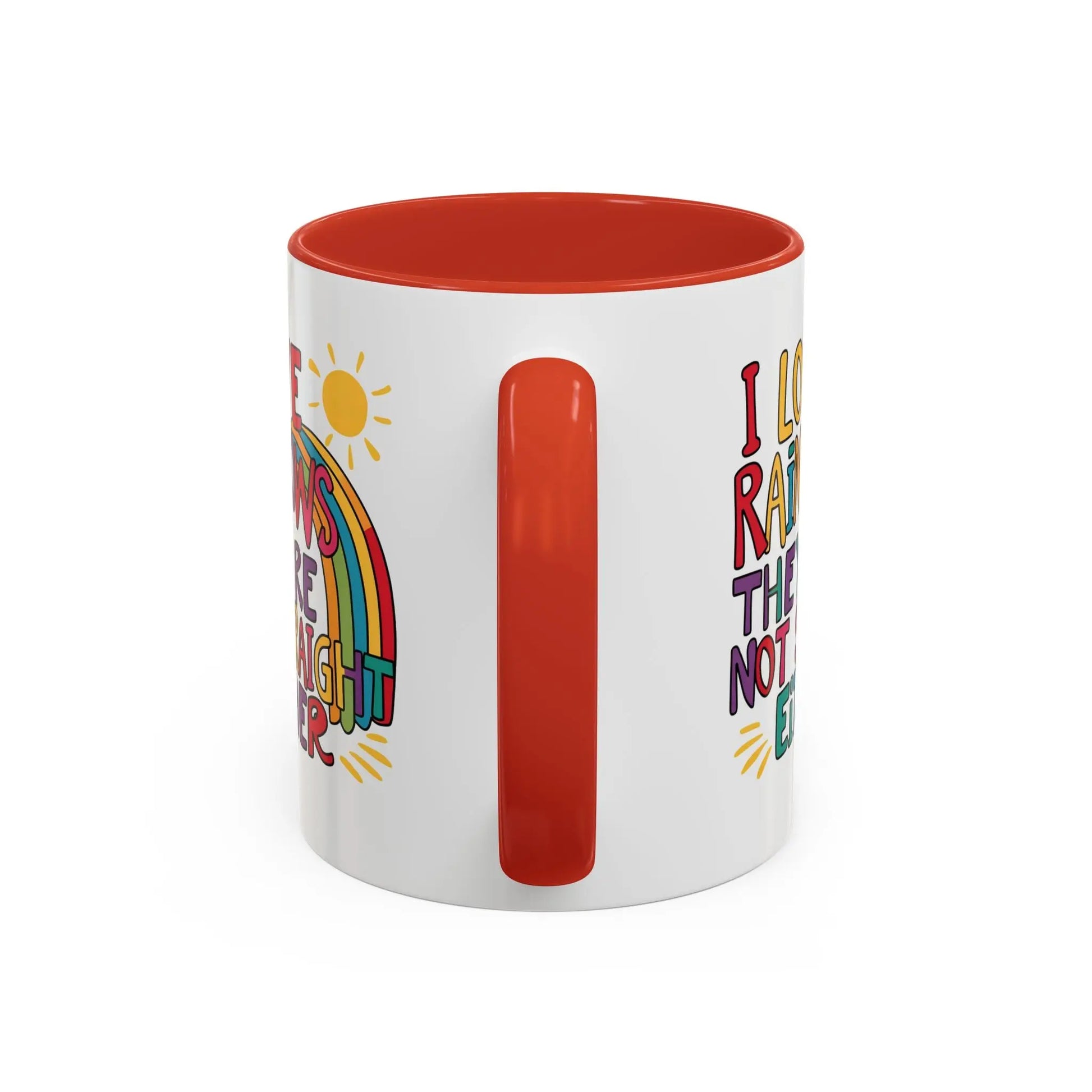 A white ceramic coffee mug with a red handle and interior, featuring the colorful text 'I LOVE RAINBOWS THEY'RE NOT STRAIGHT EITHER' along with a graphic of a rainbow and a sun.