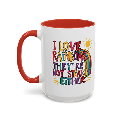 A white ceramic coffee mug with a red handle and interior, featuring the colorful text 'I LOVE RAINBOWS THEY'RE NOT STRAIGHT EITHER' along with a graphic of a rainbow and a sun.